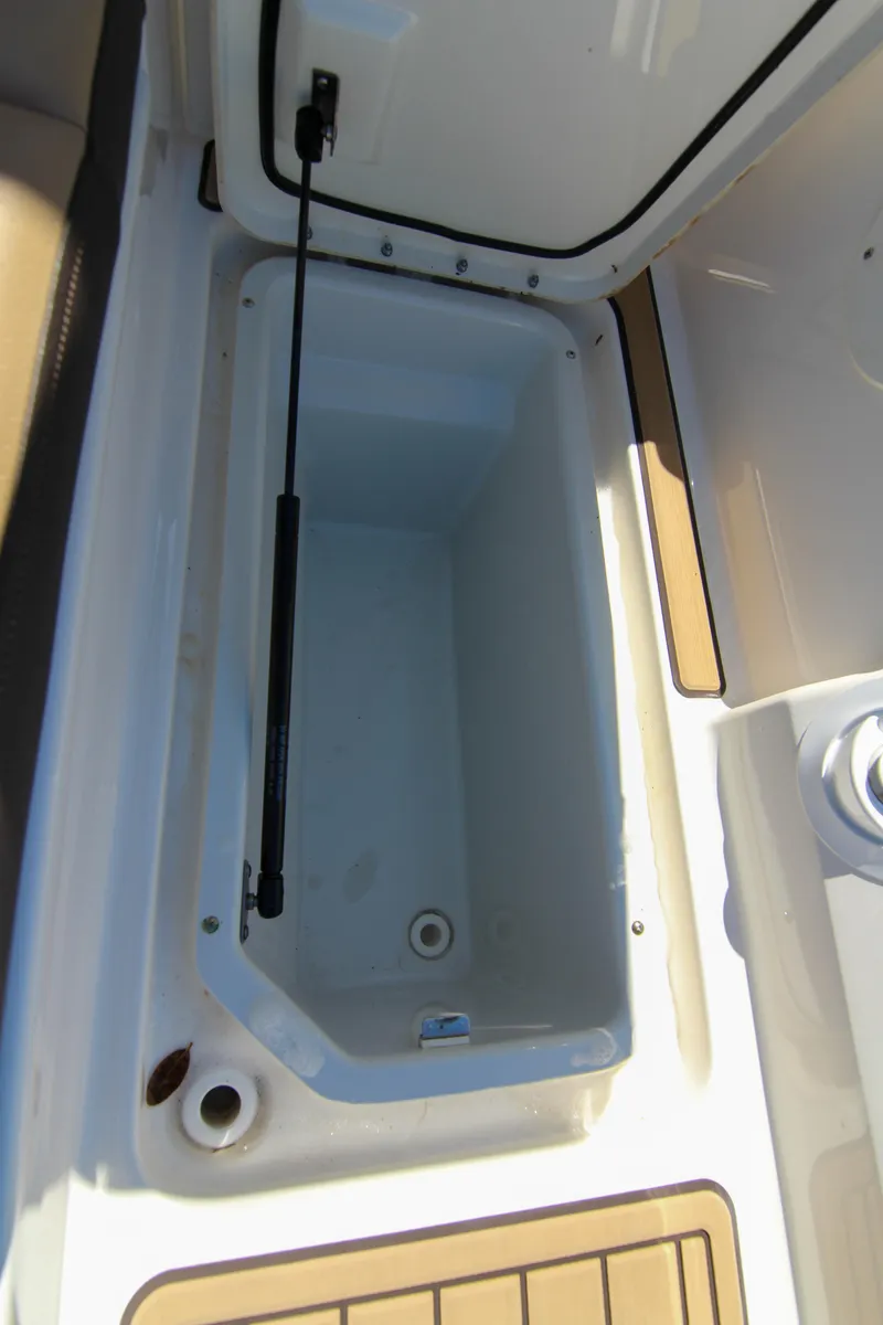 Slide: The Image of 2021 Sea Ray SDX 270 storage compartment with open lid, showcasing spacious interior. - 38
