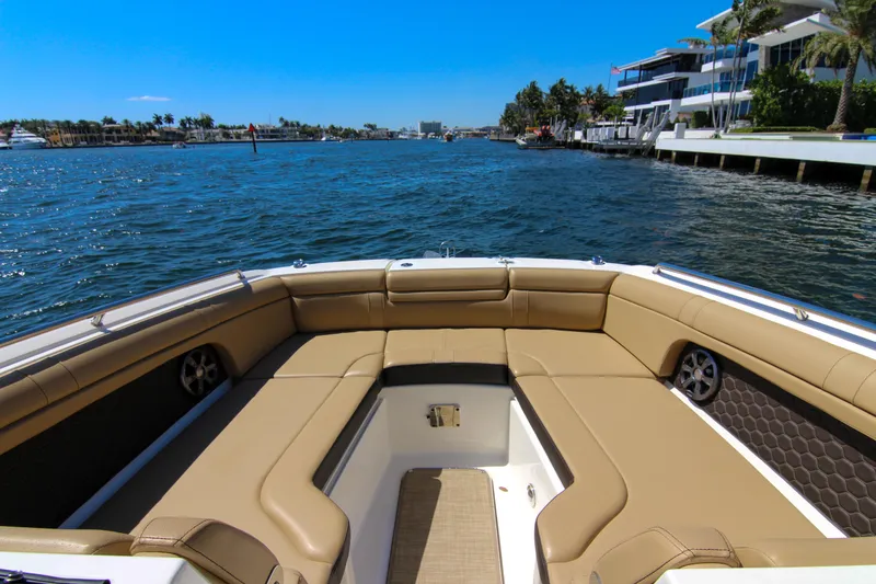 Slide: The Image of 2021 Sea Ray SDX 270 boat interior with tan seating, cruising on a sunny waterfront. - 39