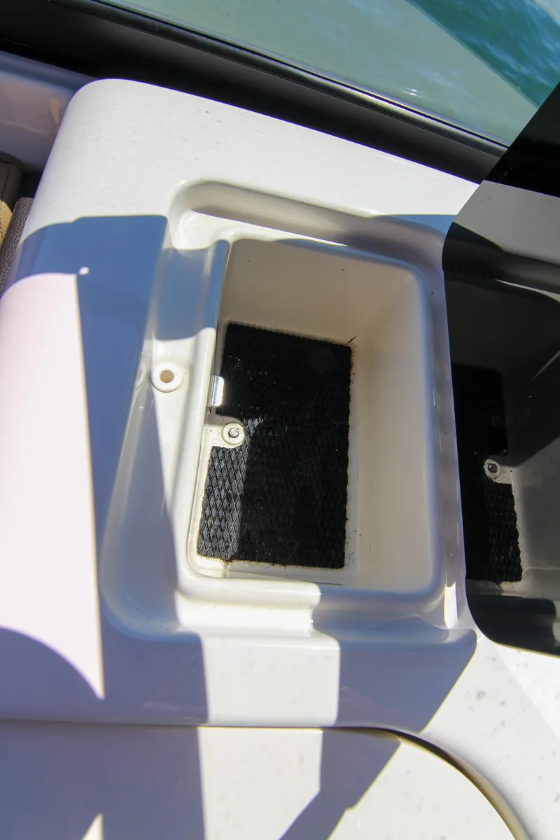 Slide: The Image of 2021 Sea Ray SDX 270 boat storage compartment, white interior, open lid, sunny day. - 48