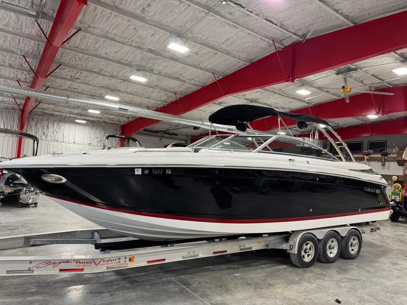 The Image of 2007 Cobalt 302 BR boat on a triple-axle trailer in a spacious indoor facility. - 1