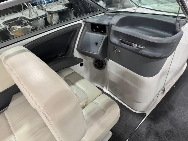 Slide: The Image of 2007 Cobalt 302 BR boat interior with white seating and dashboard details. - 16
