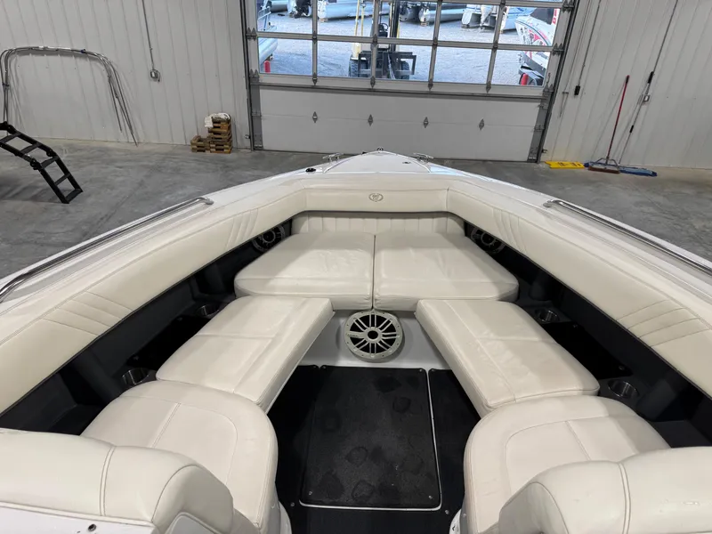 Slide: The Image of 2007 Cobalt 302 BR boat interior with white leather seating in a garage setting. - 21