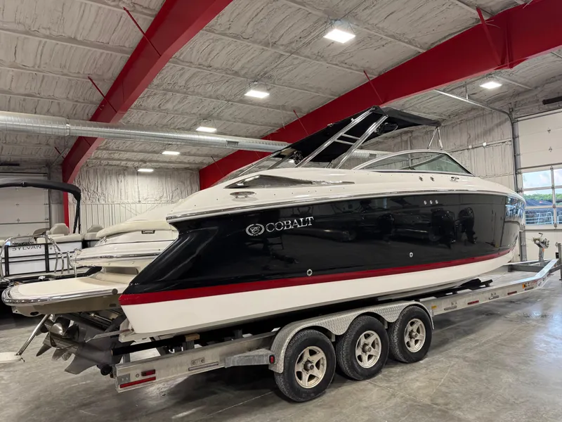 Slide: The Image of 2007 Cobalt 302 BR boat on a trailer in a spacious indoor facility. - 6
