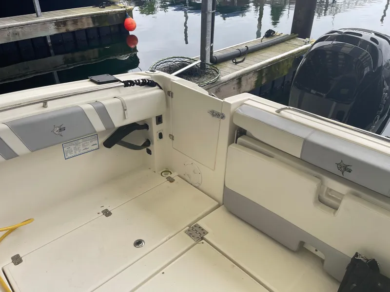 Slide: The Image of 2015 Seaswirl Striper Alaskan Edition boat interior at dock, featuring seating and storage. - 13