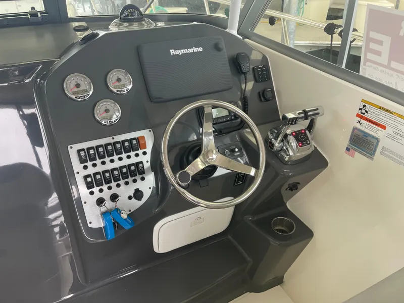 Slide: The Image of 2015 Seaswirl Striper Alaskan Edition boat dashboard with steering wheel and control panel. - 7