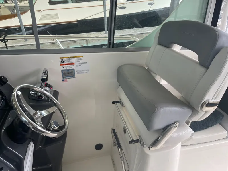Slide: The Image of 2015 Seaswirl Striper Alaskan Edition boat interior with steering wheel and cushioned seat. - 8