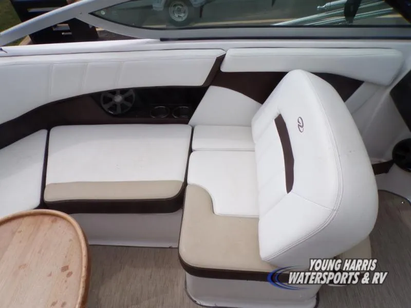 Slide: The Image of 2017 Regal 2000 ES boat interior with white and beige seating, wooden table, and speaker. - 13