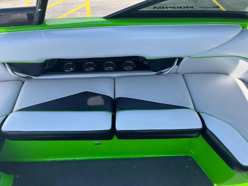 Slide: The Image of 2014 Moomba Mobius LSV interior with green and black seating, cup holders, and sleek design. - 24