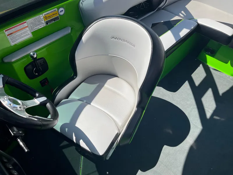 Slide: The Image of 2014 Moomba Mobius LSV boat interior with green accents and steering wheel. - 27