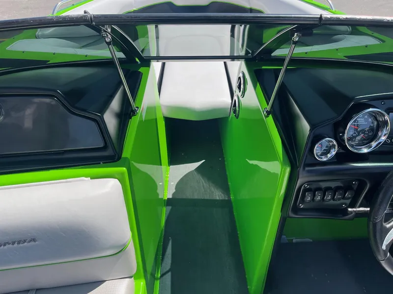 Slide: The Image of 2014 Moomba Mobius LSV boat interior with green accents and dashboard controls. - 28