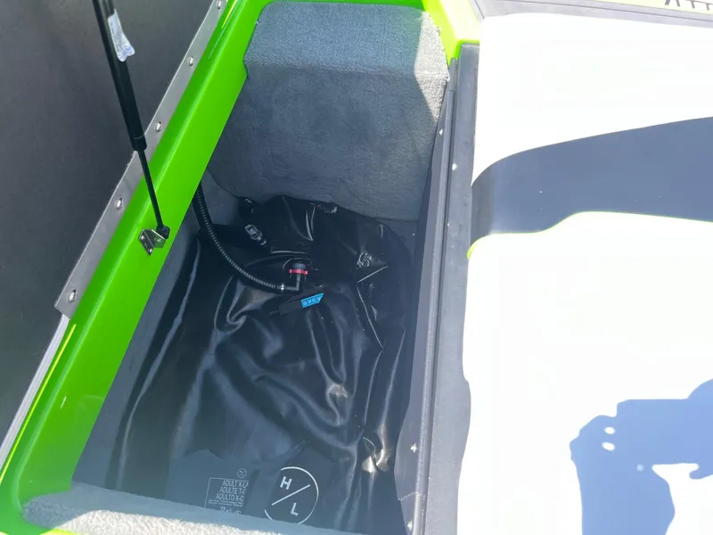 Slide: The Image of 2014 Moomba Mobius LSV storage compartment with green trim and black interior. - 31