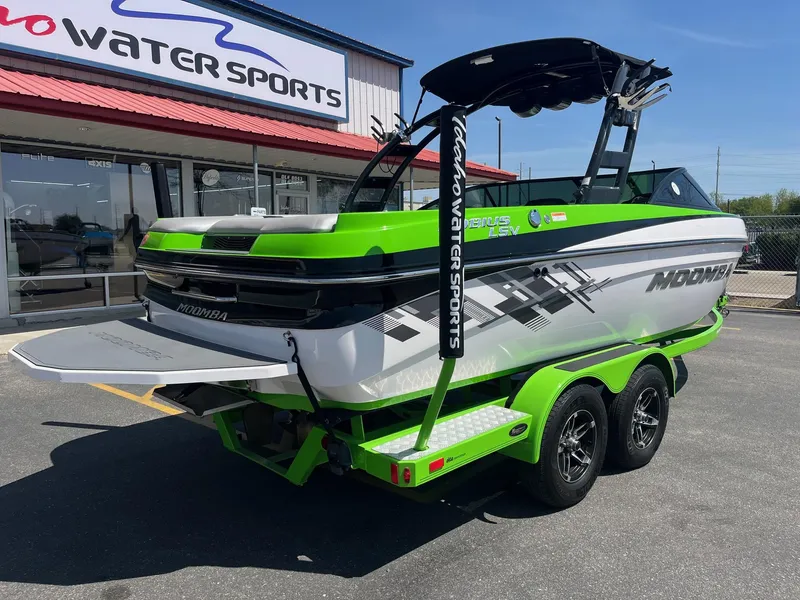 Slide: The Image of 2014 Moomba Mobius LSV boat in vibrant green at a water sports dealership. - 4