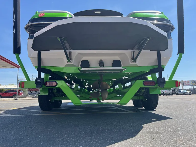 Slide: The Image of 2014 Moomba Mobius LSV boat on trailer, rear view, green and white design. - 6