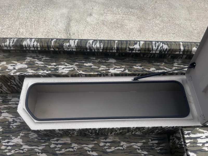 Slide: The Image of Open storage compartment in 2025 Avid 18 Commander boat with camouflage design. - 11