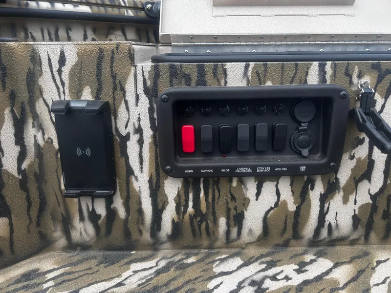 Slide: The Image of Control panel of 2025 Avid 18 Commander boat with camo design and USB ports. - 13