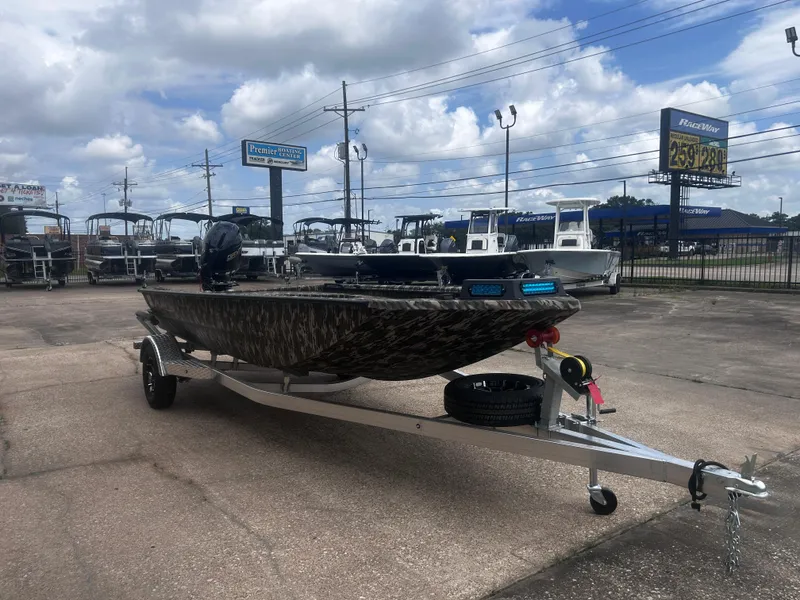 Slide: The Image of 2025 Avid 18 Commander boat on trailer at dealership under cloudy sky. - 5