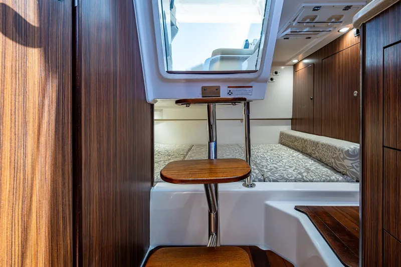 Slide: The Image of Interior of 2017 Pursuit 325 OS boat with wooden steps and cozy cabin. - 11