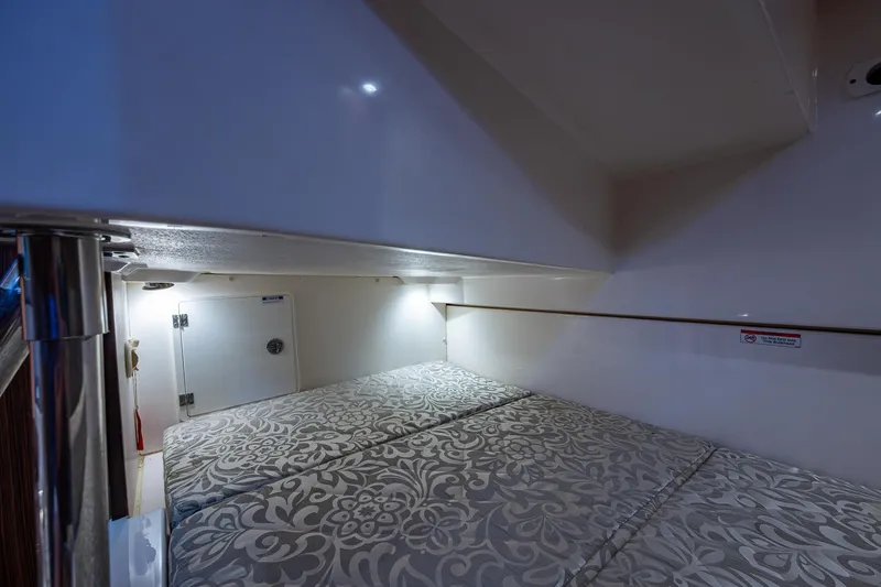 Slide: The Image of 2017 Pursuit 325 OS cabin interior with patterned bedding and ambient lighting. - 12