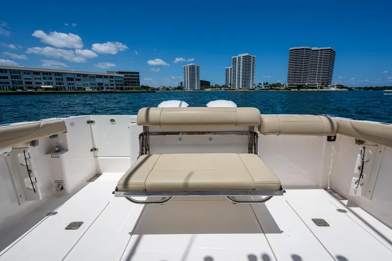 Slide: The Image of 2017 Pursuit 325 OS boat with seating, overlooking waterfront cityscape. - 16