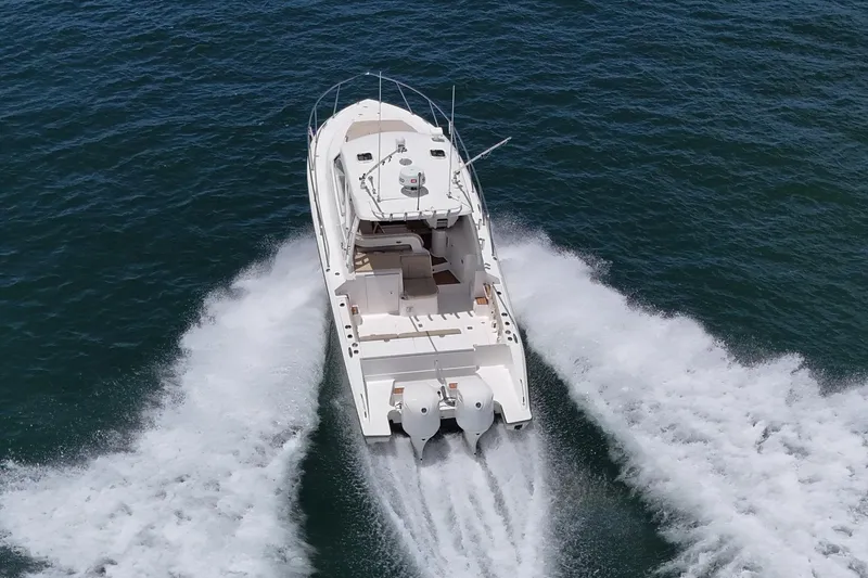 Slide: The Image of 2017 Pursuit 325 OS boat cruising on open water, aerial view. - 2