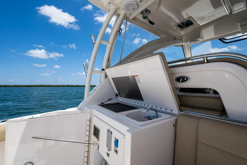Slide: The Image of 2017 Pursuit 325 OS boat interior with open storage, ocean view, and clear blue sky. - 21
