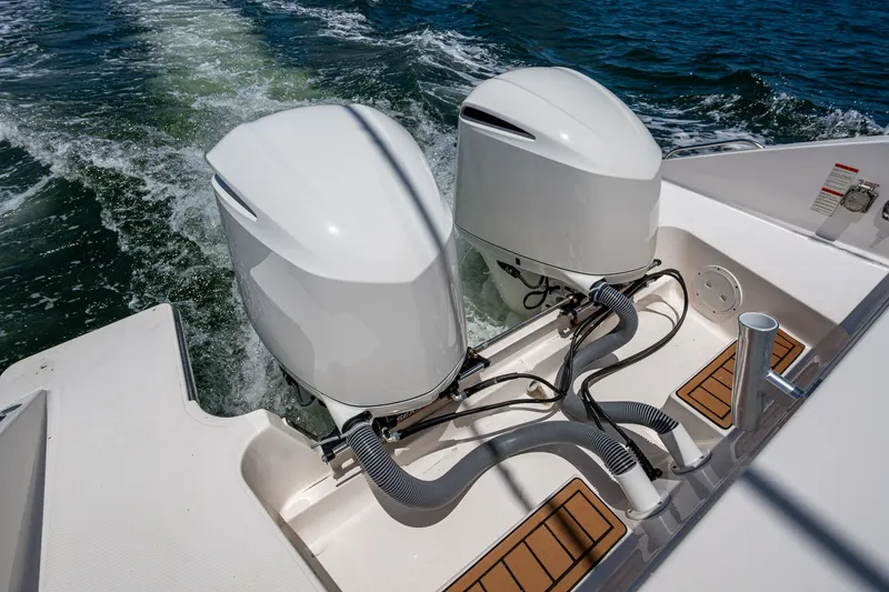 Slide: The Image of Twin outboard engines on a 2017 Pursuit 325 OS boat, cruising on water. - 23