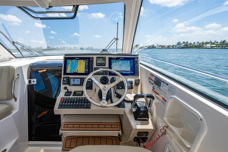Slide: The Image of 2017 Pursuit 325 OS boat cockpit with navigation equipment and ocean view. - 30