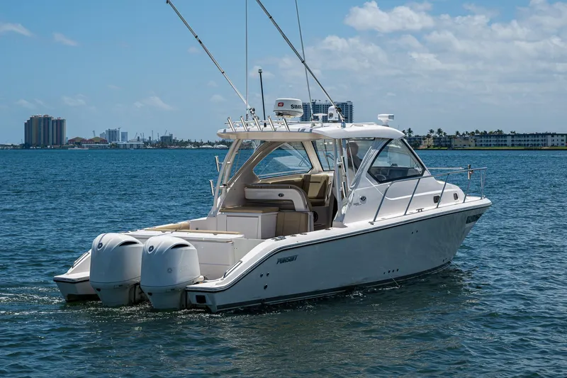 Slide: The Image of 2017 Pursuit 325 OS boat on water, clear sky, city skyline in background. - 33