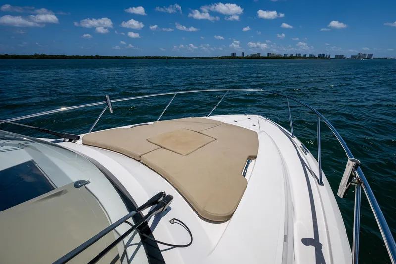 Slide: The Image of 2017 Pursuit 325 OS boat deck with sun pad, ocean view, and clear blue sky. - 4