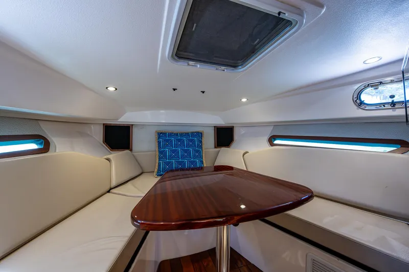 Slide: The Image of 2017 Pursuit 325 OS cabin interior with seating and wooden table. - 8