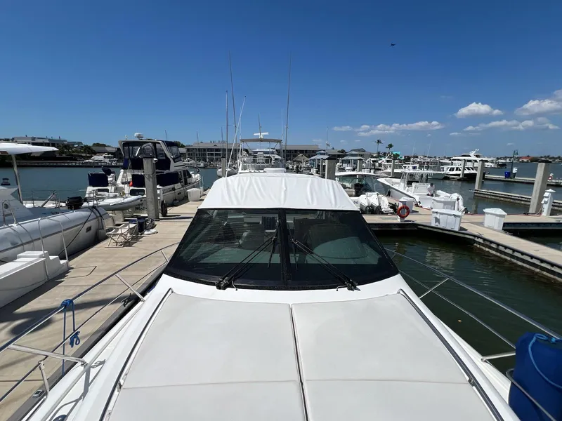 Slide: The Image of 2001 Uniesse 42 Open yacht docked at a marina under a clear blue sky. - 13