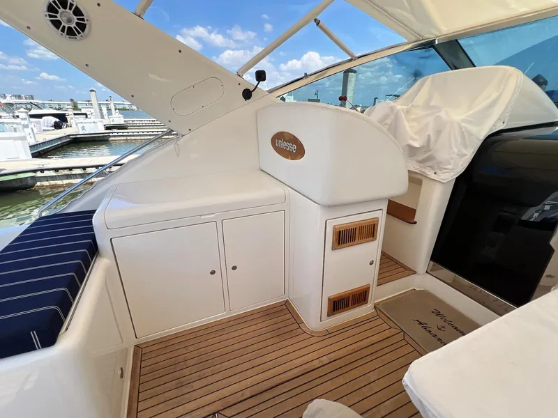 Slide: The Image of 2001 Uniesse 42 Open yacht interior with wooden deck and marina view. - 16