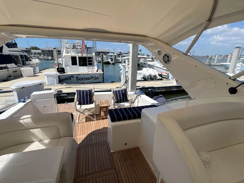 Slide: The Image of 2001 Uniesse 42 Open yacht interior with marina view, featuring comfortable seating and wooden deck. - 17