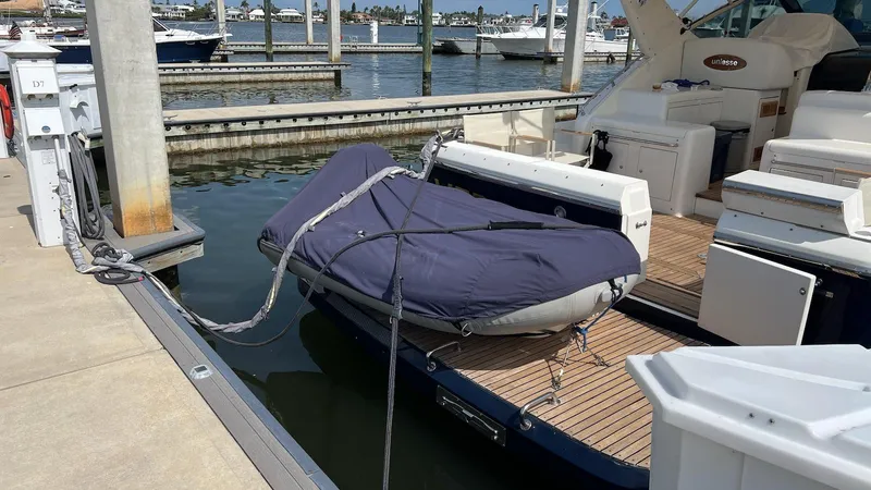 Slide: The Image of 2001 Uniesse 42 Open yacht docked with covered dinghy on the swim platform. - 34