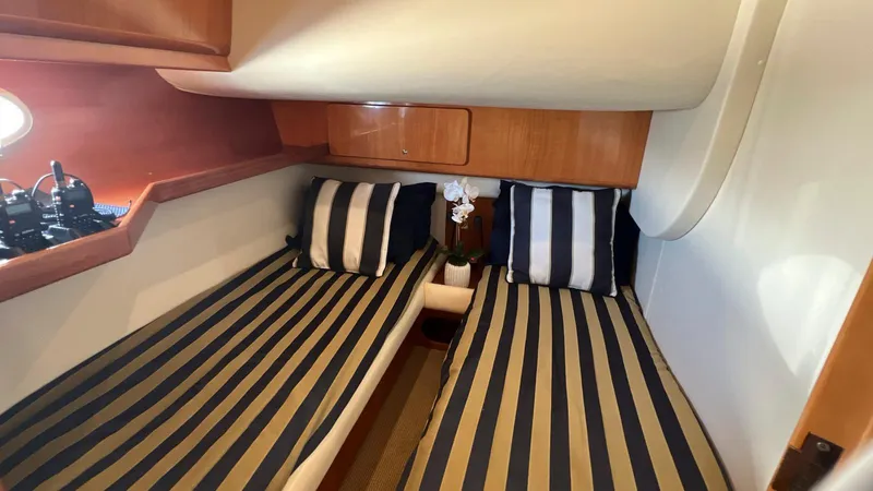 Slide: The Image of 2001 Uniesse 42 Open cabin with striped bedding and cushions. - 40