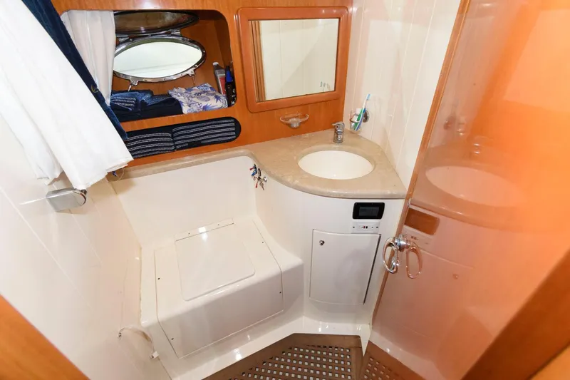 Slide: The Image of 2001 Uniesse 42 Open yacht bathroom with sink, mirror, and shower area. - 42