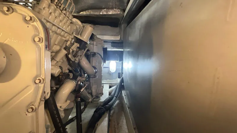 Slide: The Image of Engine room of 2001 Uniesse 42 Open yacht, showcasing mechanical components and piping. - 48