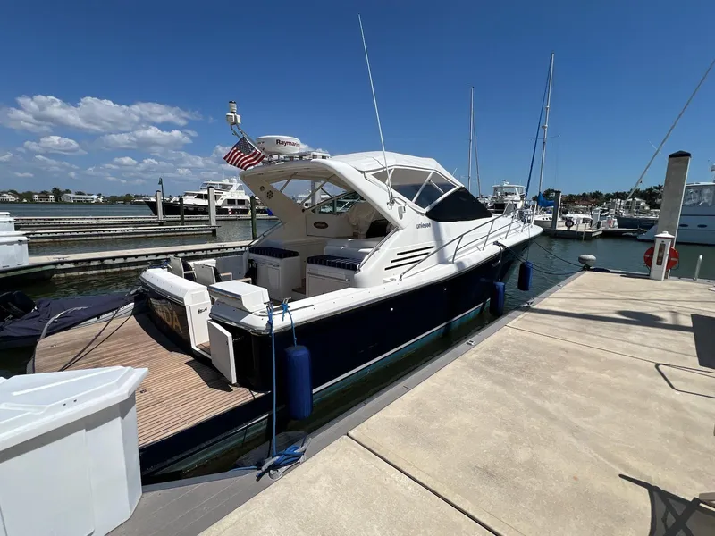 Slide: The Image of 2001 Uniesse 42 Open yacht docked at a marina under a clear blue sky. - 5