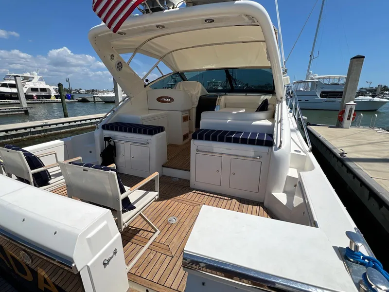 Slide: The Image of 2001 Uniesse 42 Open yacht with spacious deck, docked at marina under clear blue sky. - 6