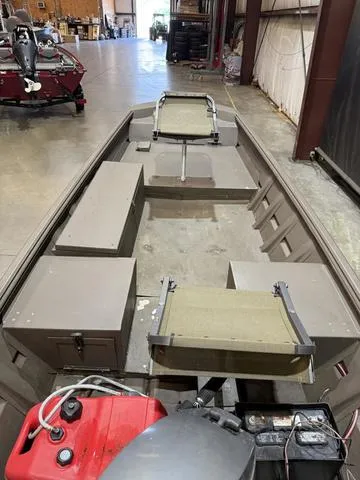 Slide: The Image of 1999 Xpress 1546 boat with Mariner 25 engine in a warehouse setting. - 6