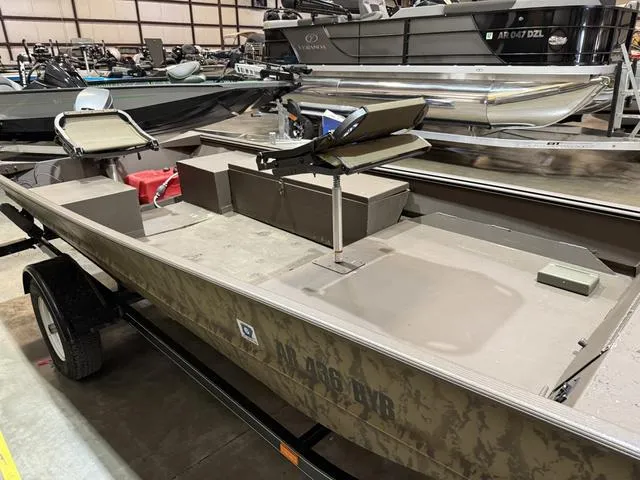 Slide: The Image of 1999 Xpress 1546 boat with Mariner 25 engine, camo design, on trailer in warehouse. - 8