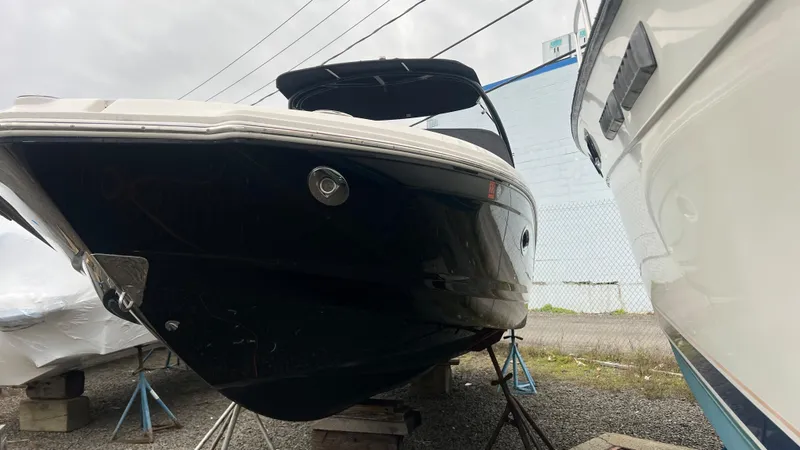 Slide: The Image of 2017 Chaparral 246 SSi boat on stands, black hull, outdoor storage. - 1