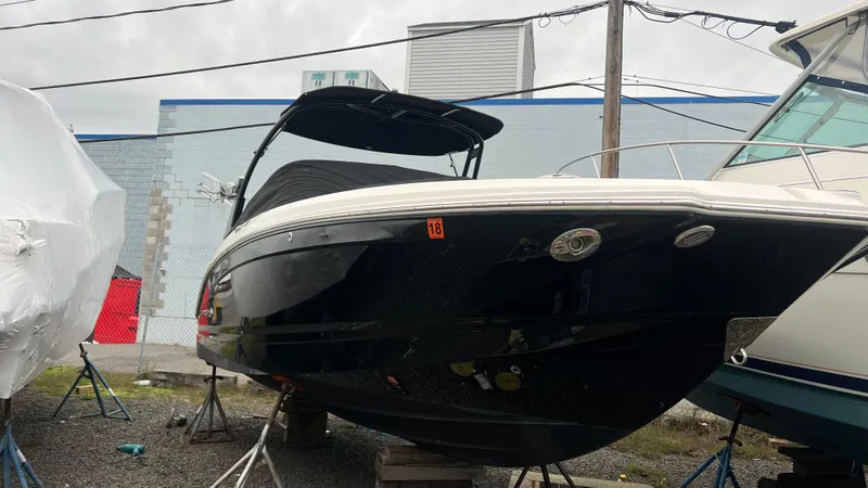 Slide: The Image of 2017 Chaparral 246 SSi boat in storage, black hull, covered, outdoor setting. - 4