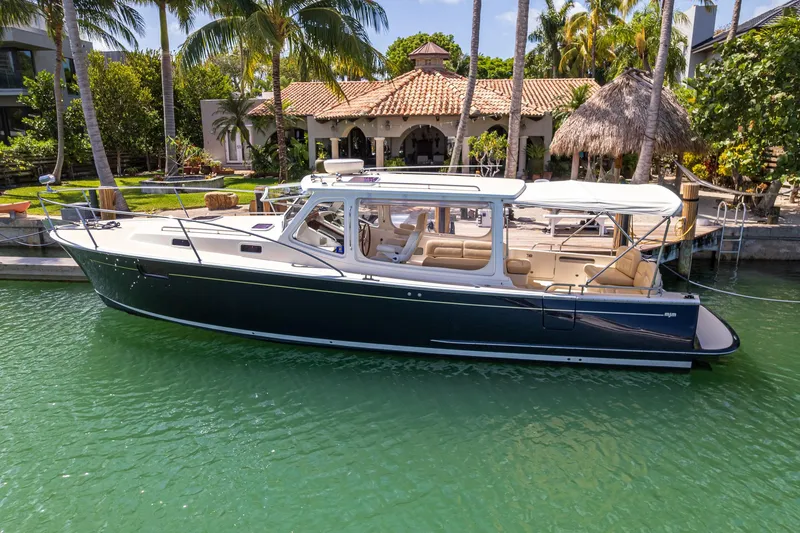 Slide: The Image of 2013 MJM 36z Downeast boat docked by a tropical waterfront home. - 11