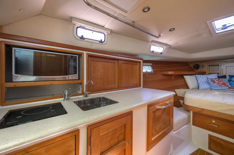 Slide: The Image of 2013 MJM 36z Downeast yacht interior with kitchenette, sink, and cozy seating area. - 23