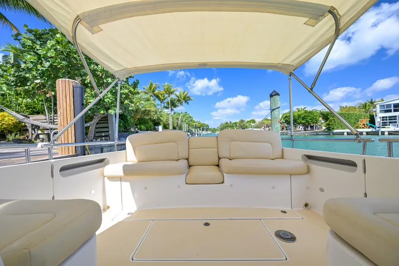 Slide: The Image of 2013 MJM 36z Downeast boat with beige seating, canopy, and scenic waterfront view. - 31