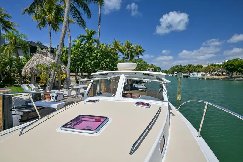Slide: The Image of 2013 MJM 36z Downeast boat docked by tropical waterfront with palm trees and clear skies. - 34