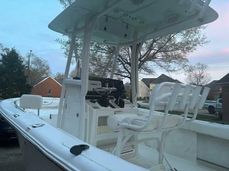 Slide: The Image of 2017 Sea Hunt Ultra 225 boat with seating and console, parked in a residential area. - 21