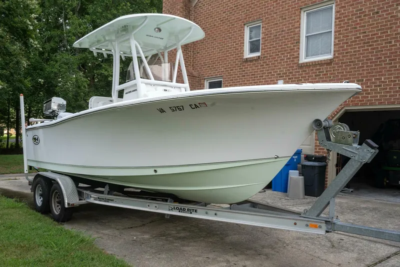 Slide: The Image of 2017 Sea Hunt Ultra 225 boat on trailer, parked in driveway near brick house. - 25