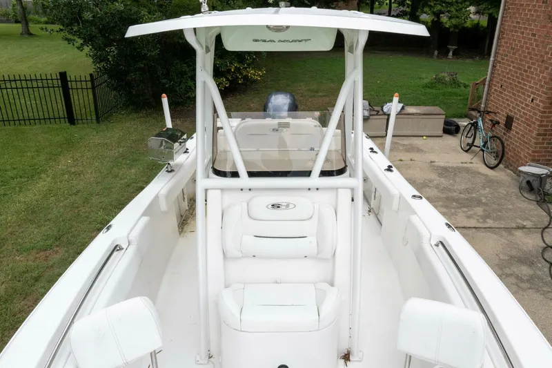 Slide: The Image of 2017 Sea Hunt Ultra 225 boat with T-top, parked in a driveway. - 39